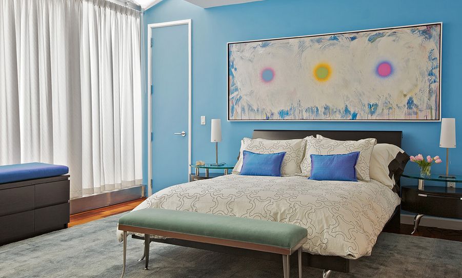 Blue walls bedroom with colorful large art