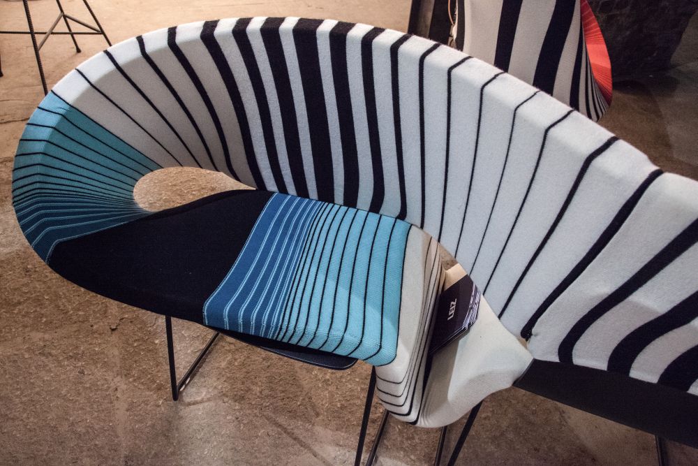 The seat and backrest are sinuously connected, forming a continuous and fluid form