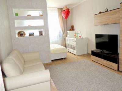 диван в светлых тонах в спальне-гостиной