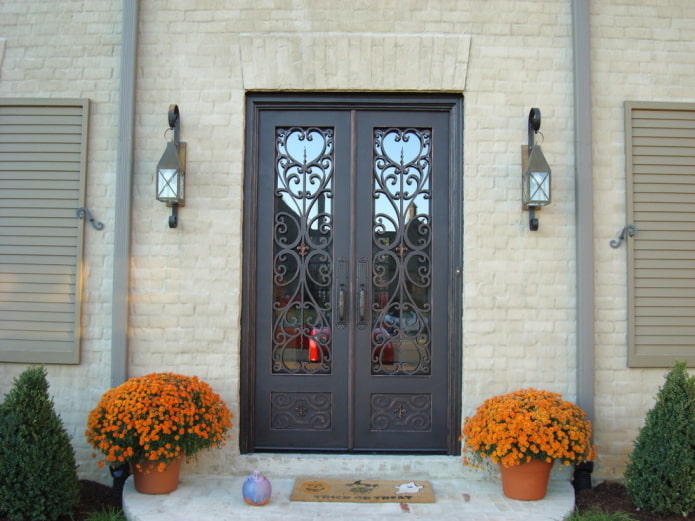 крыльцо загородного дома с входной дверью с ковкой и стеклом