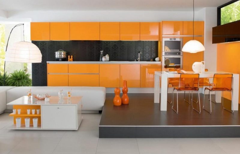 Яркая оранжевая кухня с обеденной зоной