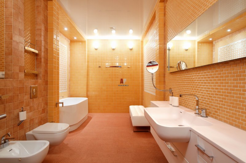 Вытянутая ванная с туалетом в оранжевых тонах
