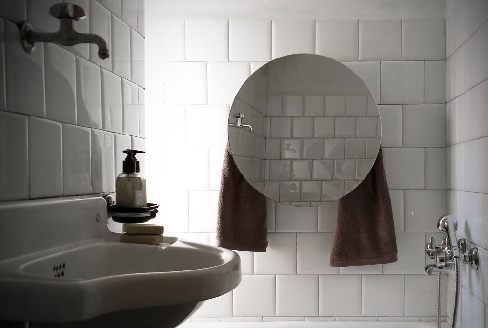 Полотенцесушитель с зеркалом на стене ванной комнаты