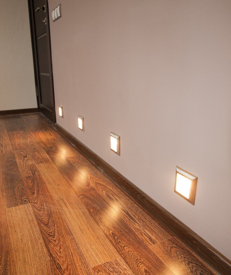 Квадратные светильники в нижней части стены коридора