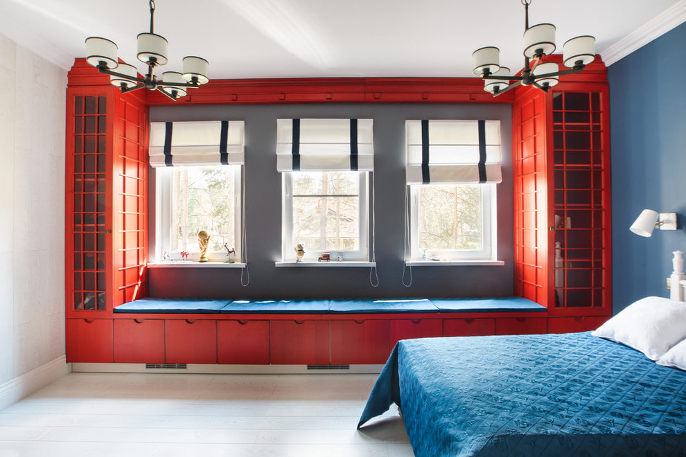 Красные шкафчики вокруг окна в спальной комнате