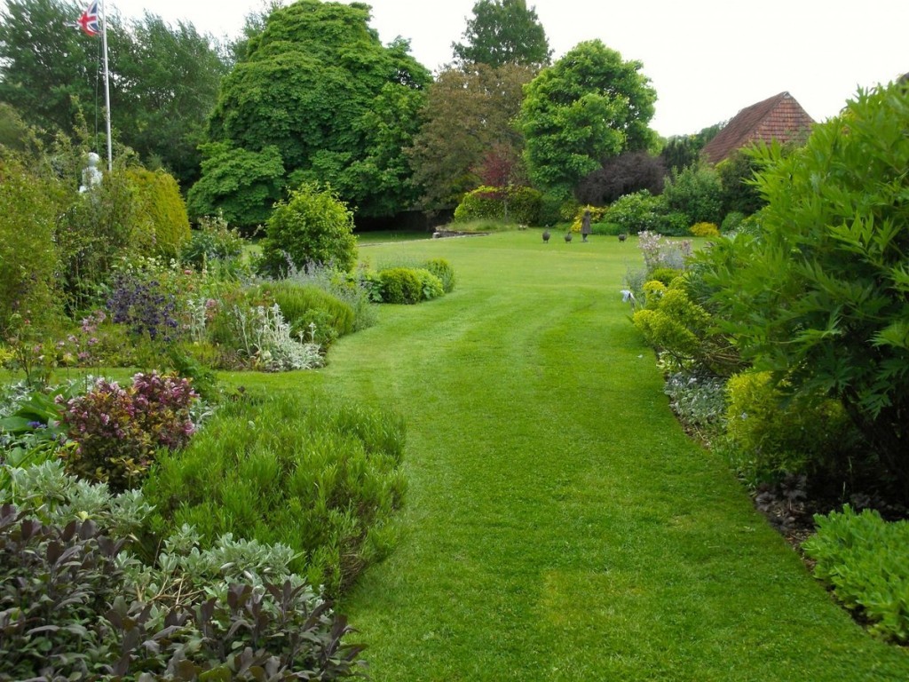 Зеленая лужайка в саду английского стиля