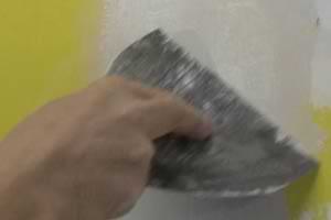 photo skimming a second coat of joint compound over a drywall paper patch