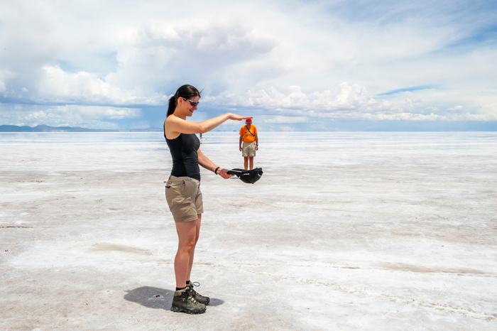 Forced perspective photo of a woman seemingly holding a small man in her hands