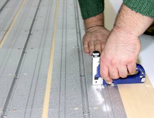 Для монтажа используют промежутки между досками, или фрезеруют пазы с нужными параметрами Теплый пол на деревянный пол под линолеум: технологии, материалы и самостоятельное выполнение работ