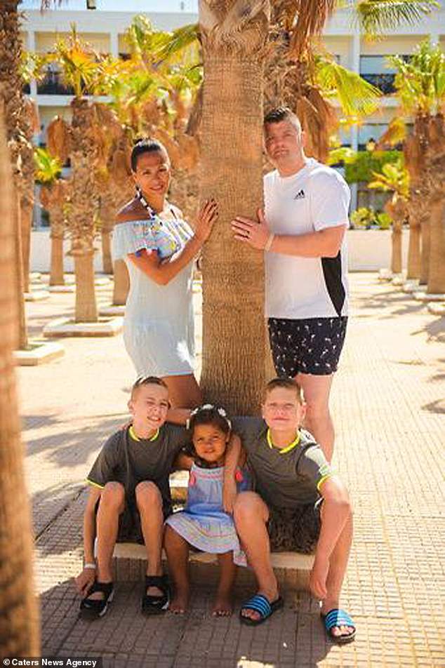 Sophia Cooper, who lives in Redditch, Worcs, and is a mum of two white boys and a black girl, has opened up about the racism her daughter has faced. Pictured, Chris and Sophia and their kids - Flossy, four, who is black - and Fin, 11, and Maxwell, eight, who are white