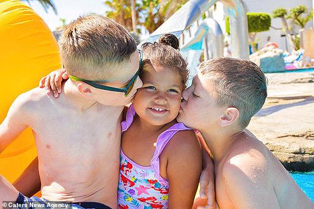 Sophia says she is regularly stopped in the street by strangers who ask why her daughter, Flossy, four, is black - when her two sons, Fin, 11, and Maxwell, eight, are white. Pictured, the siblings together