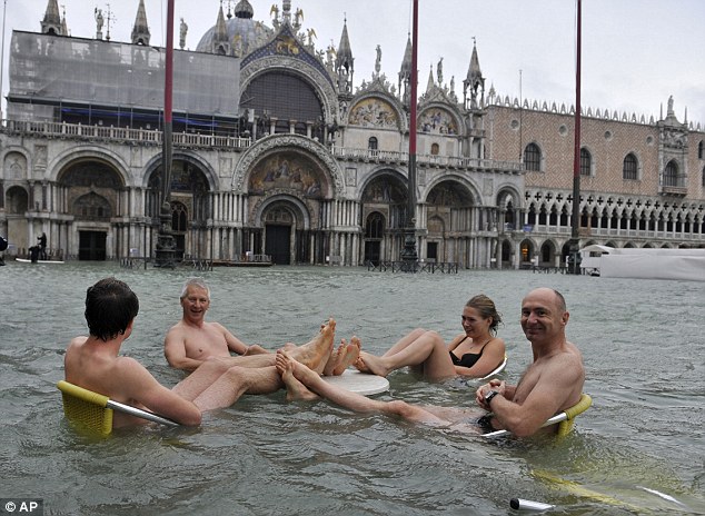 A group of people sit at a table in a flooded St Mark