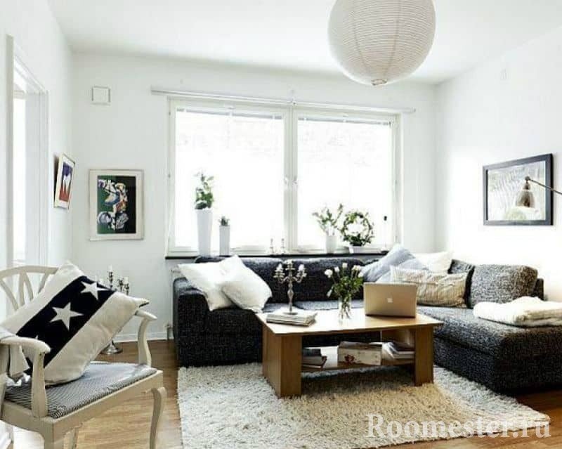 Маленькая гостиная в белом с темным угловым диваном и окном Маленькая гостиная в белом с темным угловым диваном и окном