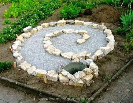 Laying out the basic shape of the spiral on top of the gravel base. 