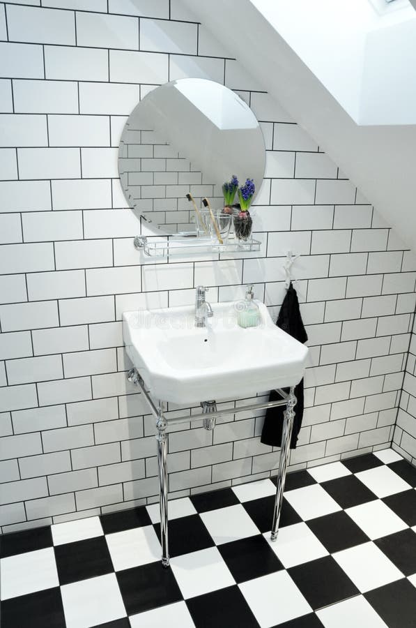 Classy toilet. Furnished toilet in a classy, minimalistic style. Black and white tiles. Compostable bamboo toth brush and a Hyacint on the shelf royalty free stock photography