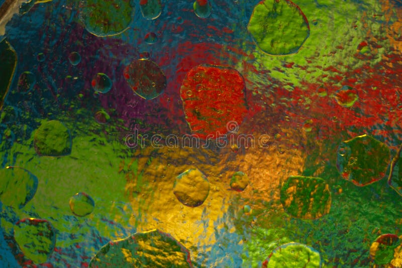 Colored objects through corrugated glass when mixing water and oil. stock image