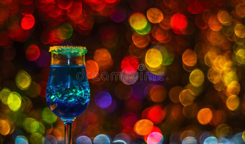 Colored drink in glass, cocktail, night lights bokeh background royalty free stock image