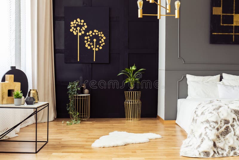 Dark grey bedroom interior with fur rug, gold accessories, simple painting and window with curtains in the real photo stock image