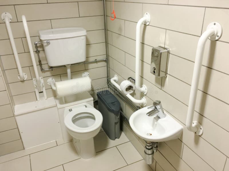 Disabled assisted bathroom toilet neutral tiles and white grab rails. Uk royalty free stock photos