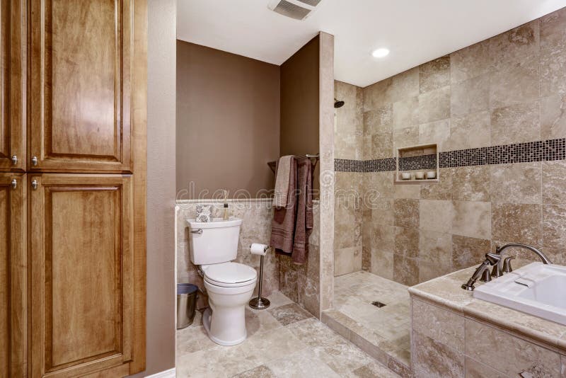 Empty bathroom interior. Light brown tile, bath tub and toilet. Empty bathroom interior. Light brown tile, bath tub, shower and toilet royalty free stock photography