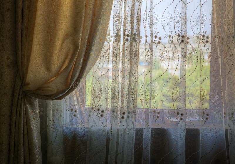 Gathered curtains and blinds on the window of the room stock photography