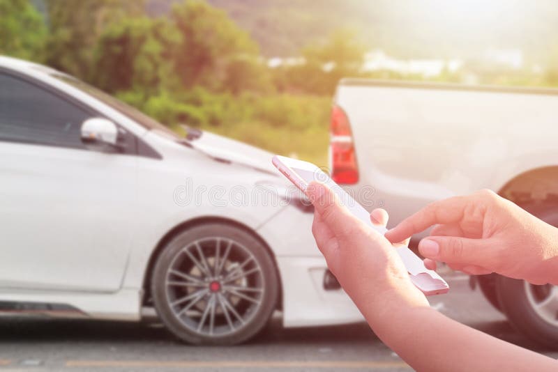 Hand of woman using smartphone and blur of her broken car parking on the road. Contacting car technician, Insurance or need help stock photos