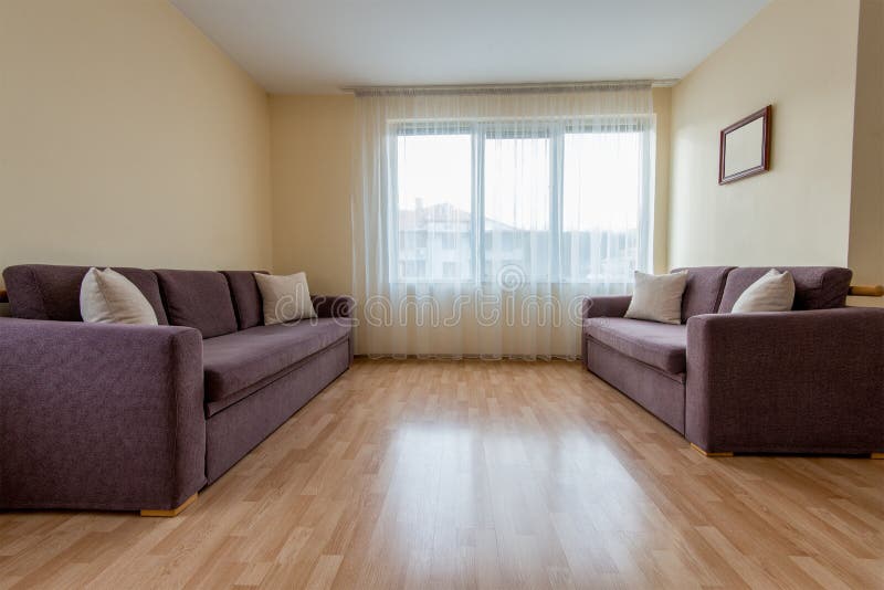 Living room with a sofa, windows and curtains royalty free stock photo