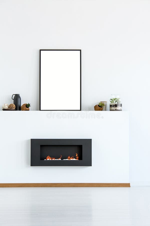 Mockup of empty poster above black fireplace in simple white living room interior. Real photo. With a place for your graphic royalty free stock images