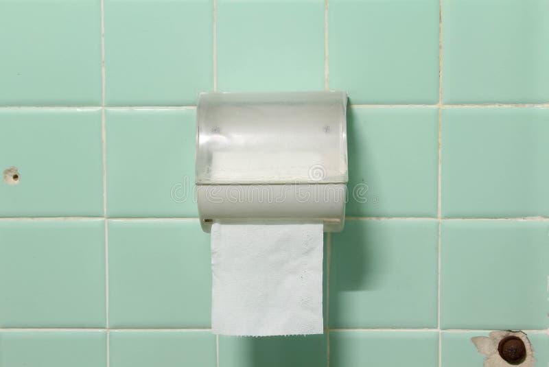 The toilet paper holder on tiles wall. Roll of toilet paper in a plastic holder on old green tiles wall stock images