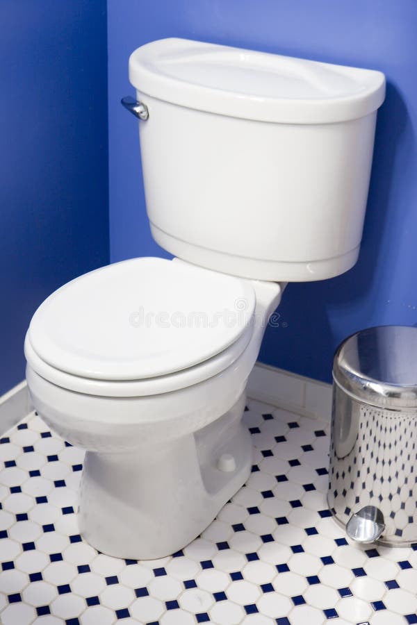 Toilet. In blue bathroom with tile floor royalty free stock photo