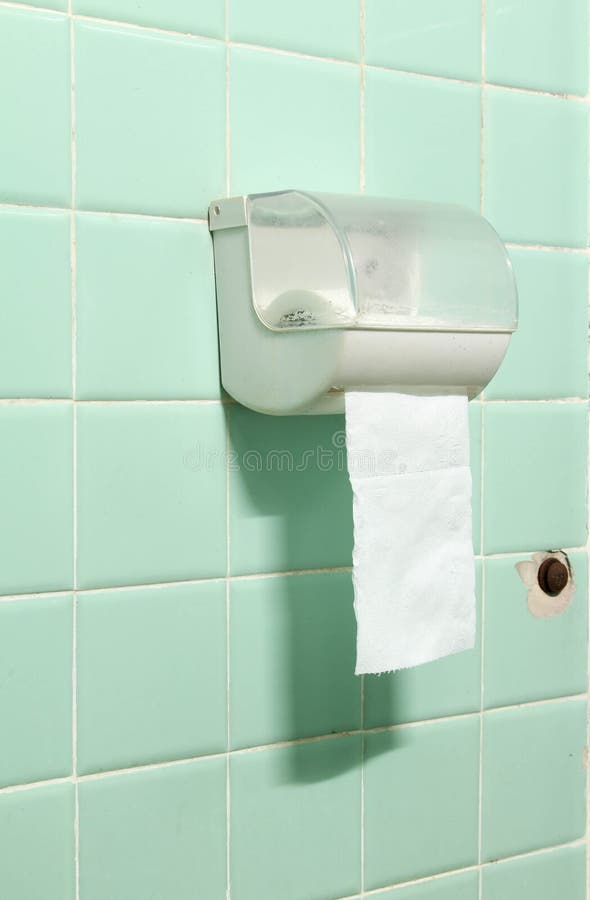 The toilet paper holder on tiles wall. Roll of toilet paper in a plastic holder on old green tiles wall stock photos