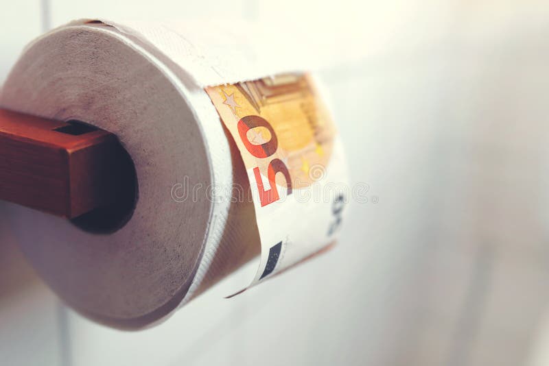 Toilet paper roll hanging on wooden holder in tiled bathroom with large banknote between sheets. Panic buying concept in times of global pandemic - gloomy stock photos