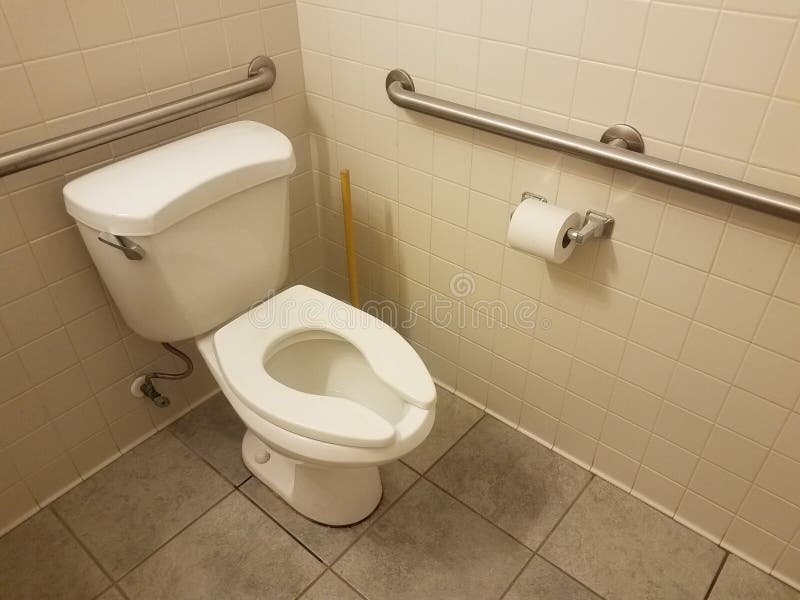 White toilet and tiles and plunger and toilet paper in bathroom. White toilet and tiles and plunger and toilet paper with metal railings in bathroom royalty free stock photography