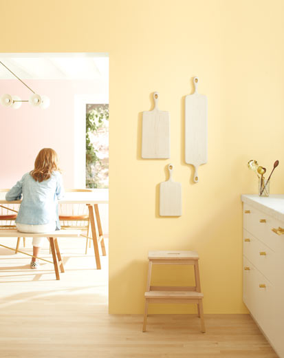 A light kitchen with pale yellow walls and white-painted cabinets