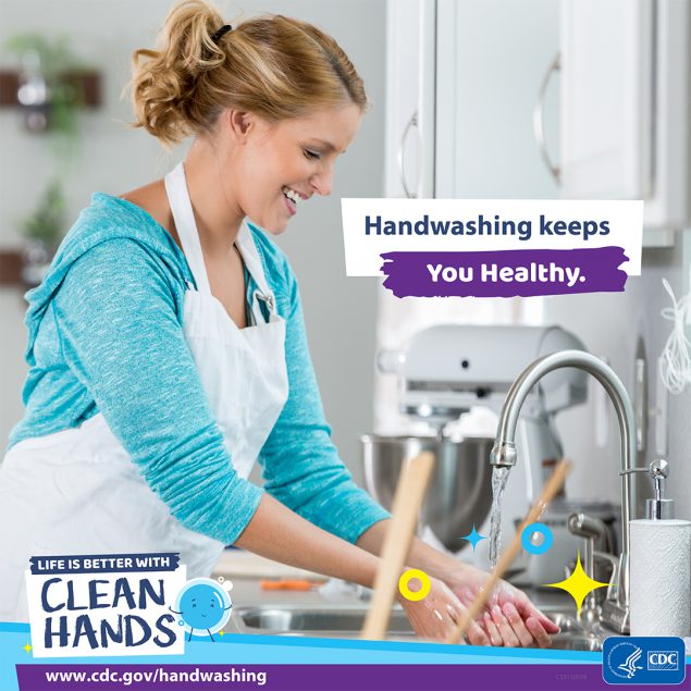 A woman washing hands in her kitchen.