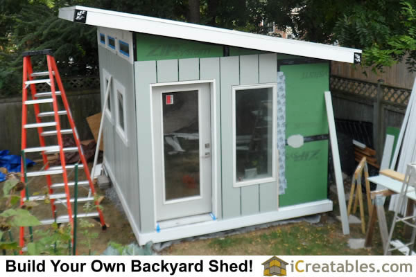 Install cement board siding on shed exterior