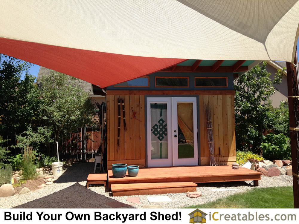 Sun shade canopy sail attached to modern shed plan in backyard.